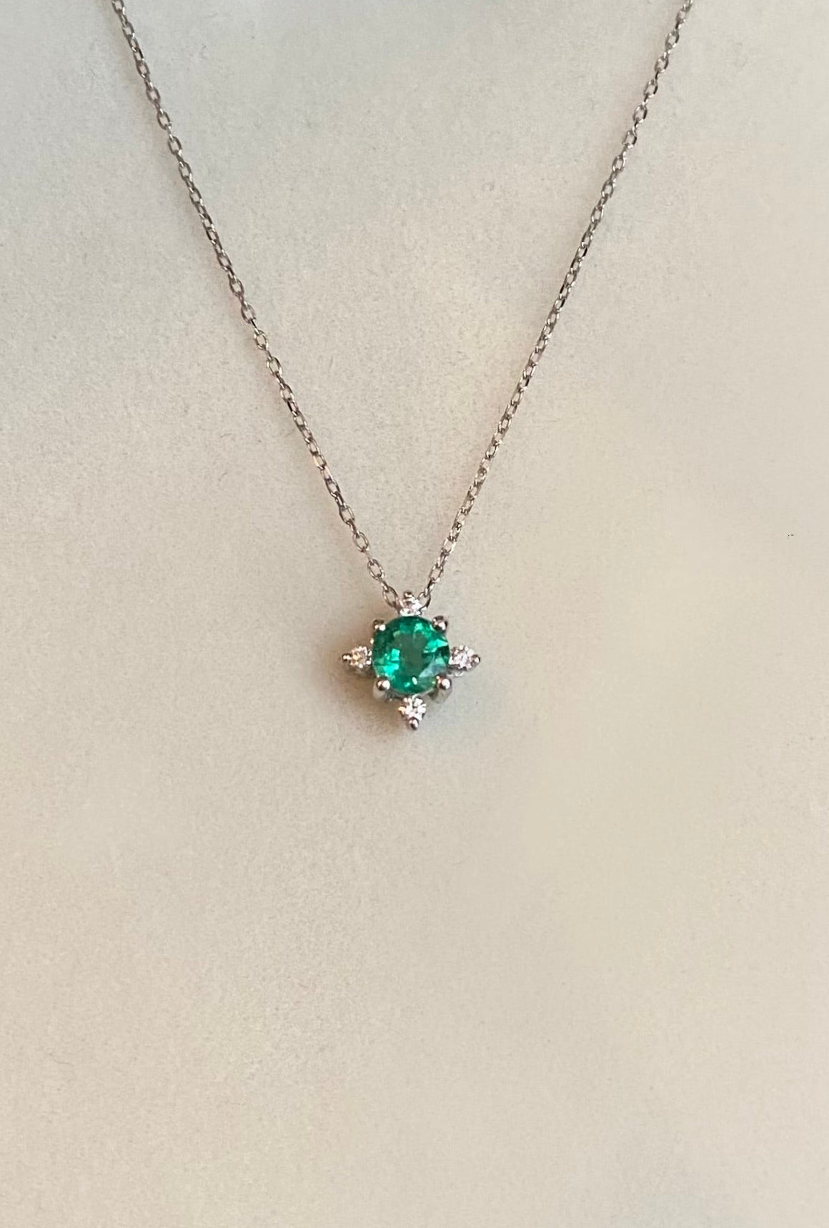 Collana in oro bianco 750 con ciondolo smeraldo tondo e diamantini — Zumpano Gioielli